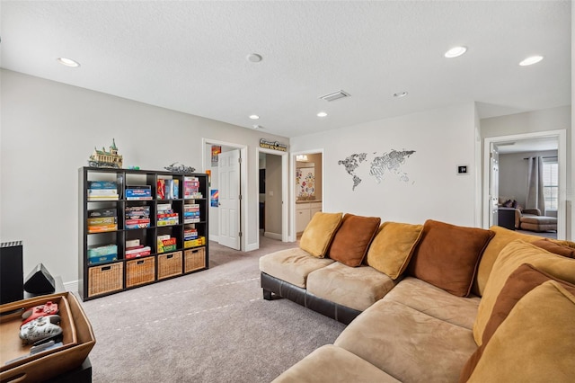 carpeted living room with a textured ceiling, baseboards, and recessed lighting