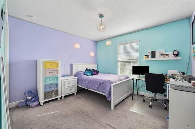 carpeted bedroom with a textured ceiling and baseboards