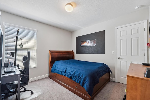 carpeted bedroom with a textured ceiling and baseboards