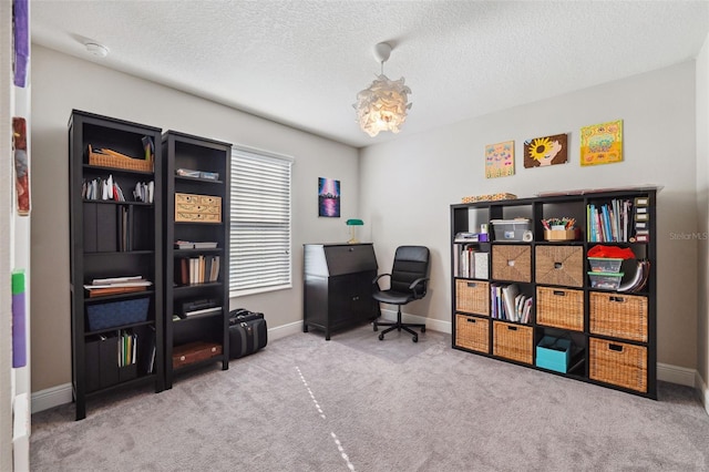 carpeted home office with a textured ceiling and baseboards