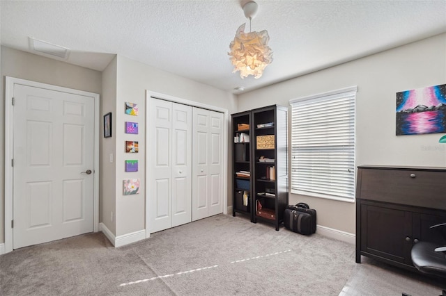 interior space featuring a closet, carpet flooring, a textured ceiling, and baseboards