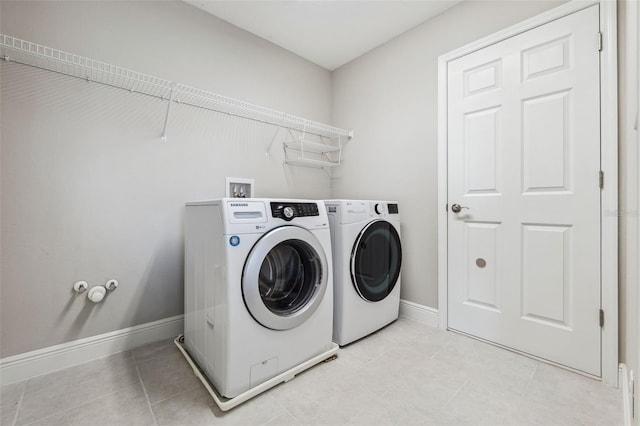 laundry area featuring laundry area, independent washer and dryer, baseboards, and light tile patterned floors