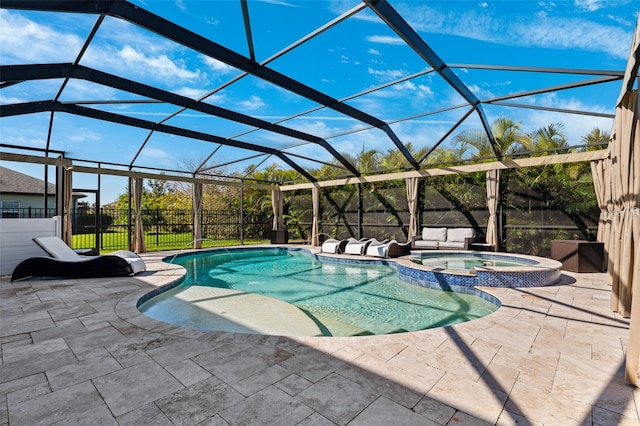 view of pool featuring a patio, glass enclosure, fence, and a pool with connected hot tub