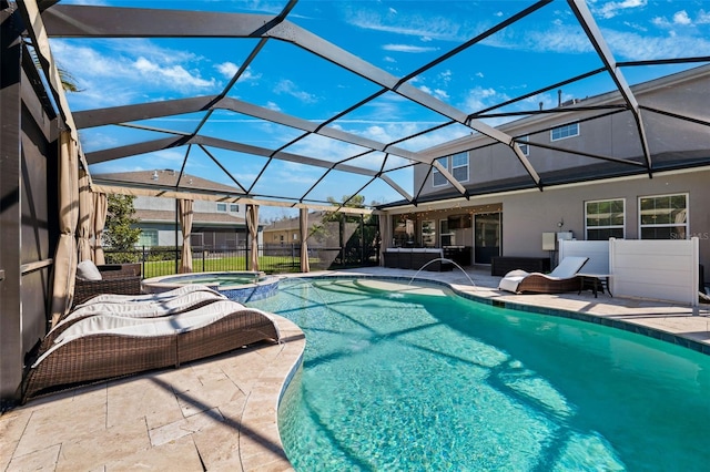 view of pool featuring glass enclosure, a patio area, and a pool with connected hot tub