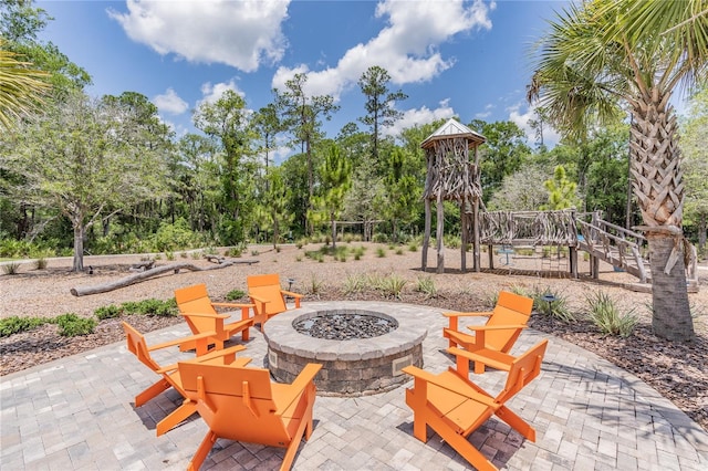 4195 Welling Ter, Land O Lakes, FL 34638 - view of patio / terrace featuring a fire pit, a playground, and view of wooded area
