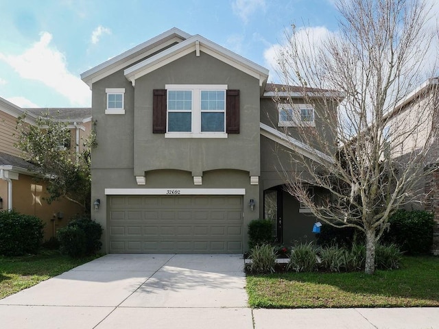 traditional-style home featuring a garage, concrete driveway, and stucco siding