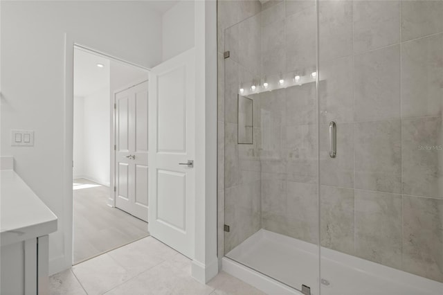 bathroom with a stall shower and tile patterned flooring