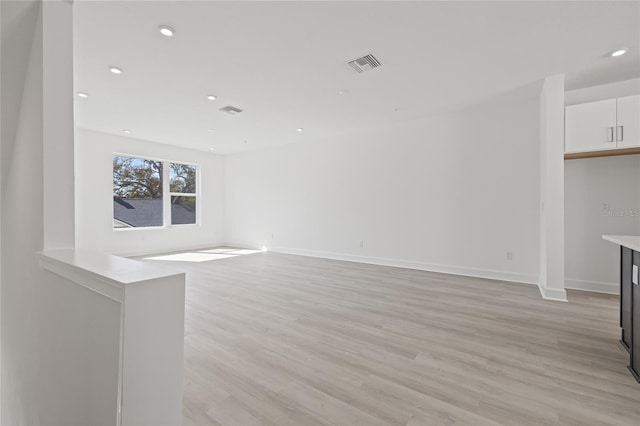 unfurnished living room featuring baseboards, light wood-style flooring, visible vents, and recessed lighting