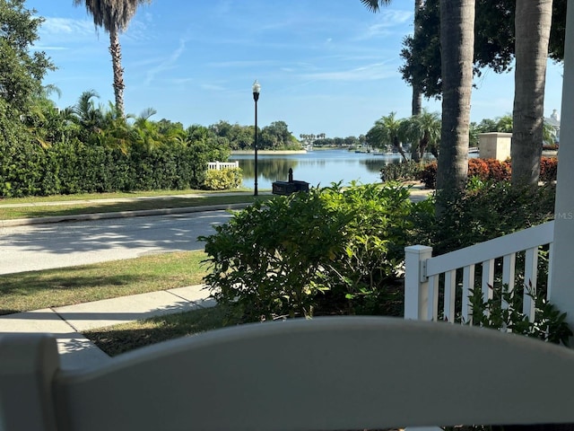 view of road with a water view, street lighting, sidewalks, and curbs