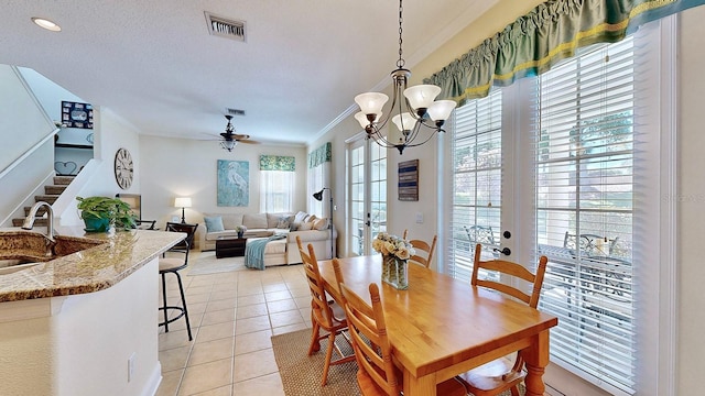 dining area featuring light tile patterned floors, visible vents, ornamental molding, and french doors