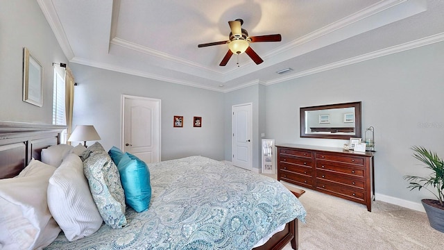 bedroom with a raised ceiling, light carpet, crown molding, and visible vents