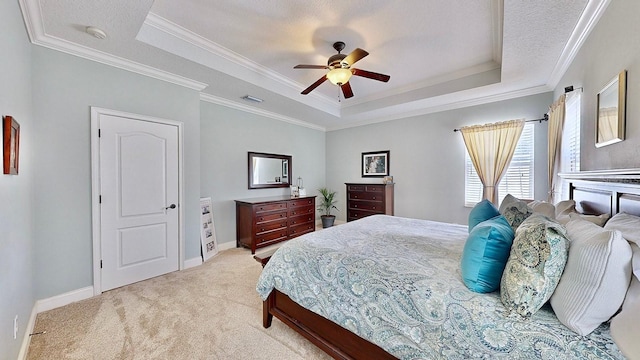 bedroom featuring ornamental molding, a tray ceiling, light carpet, and baseboards