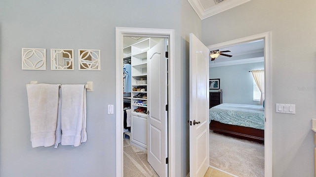 bathroom featuring crown molding, a spacious closet, and ensuite bathroom