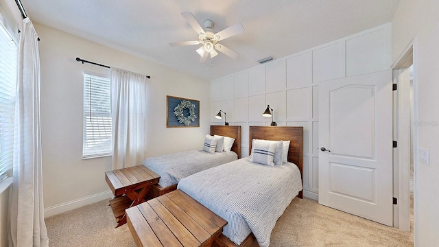 bedroom featuring light carpet, a ceiling fan, visible vents, and baseboards