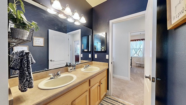 bathroom featuring double vanity, a sink, and baseboards