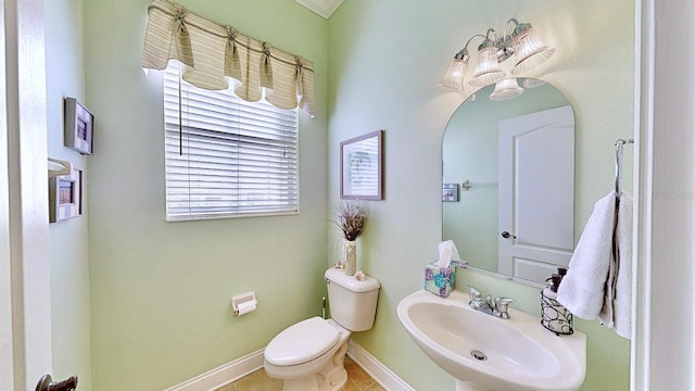 bathroom featuring toilet, baseboards, a sink, and tile patterned floors