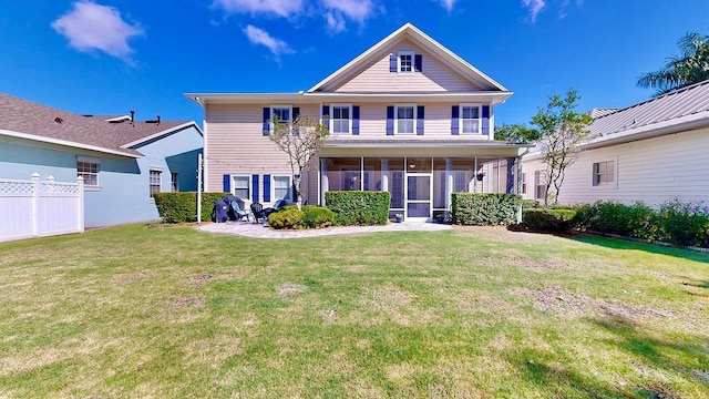 rear view of house featuring a yard and fence