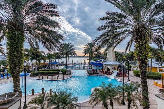 pool with a water slide and a patio