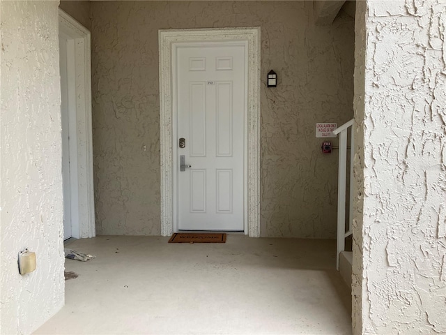 doorway to property featuring stucco siding