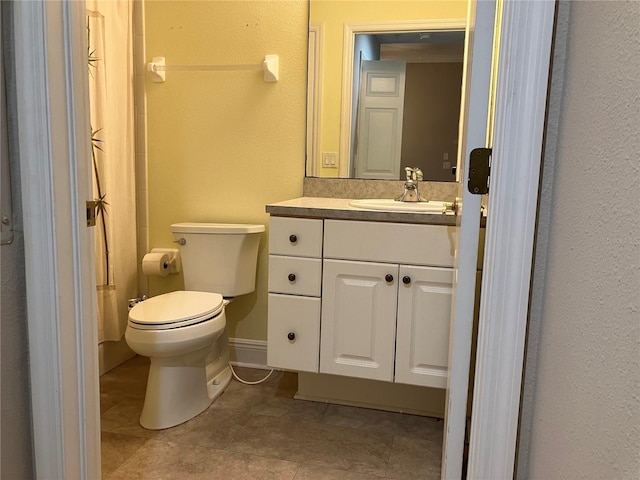 full bath with toilet, tile patterned flooring, baseboards, and vanity