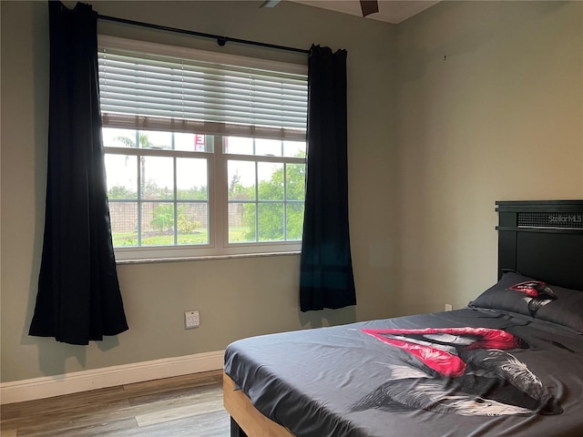 bedroom with light wood-type flooring and baseboards