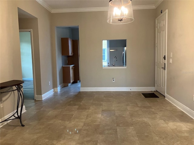 interior space featuring a chandelier, crown molding, a sink, and baseboards