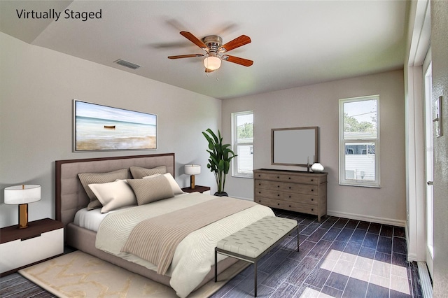 bedroom featuring ceiling fan, wood finish floors, visible vents, and baseboards