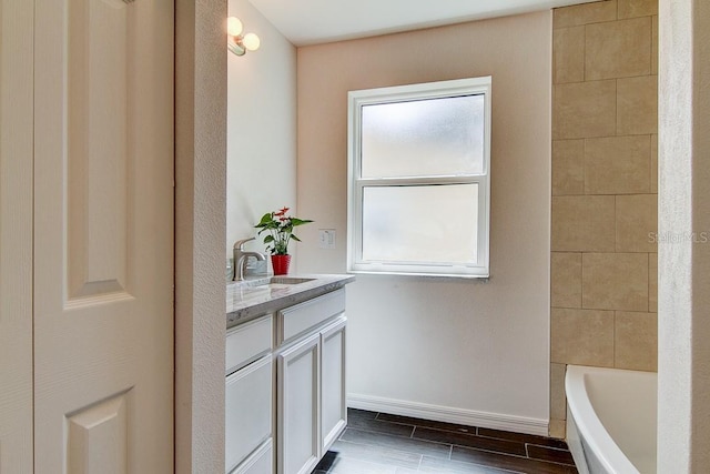 bathroom featuring visible vents, wood finish floors, vanity, and baseboards