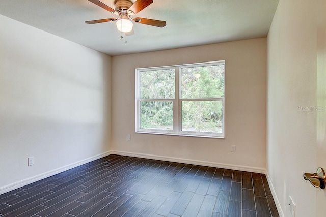 empty room with dark wood-style floors, a ceiling fan, and baseboards