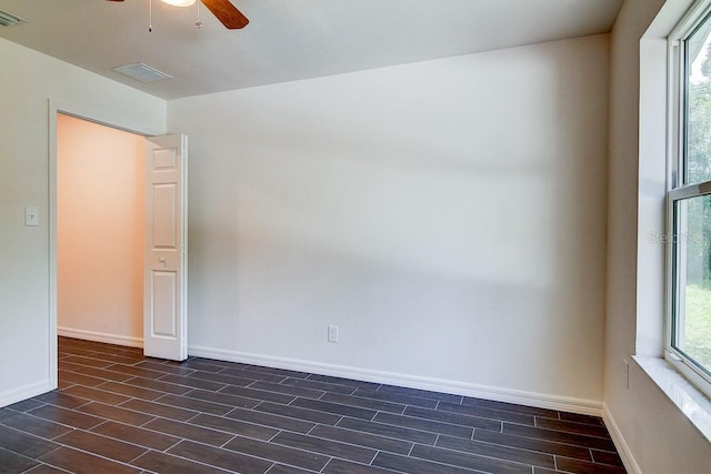 empty room with wood tiled floor, visible vents, and baseboards