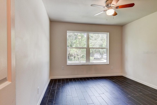 empty room featuring dark wood-style floors, baseboards, and a ceiling fan