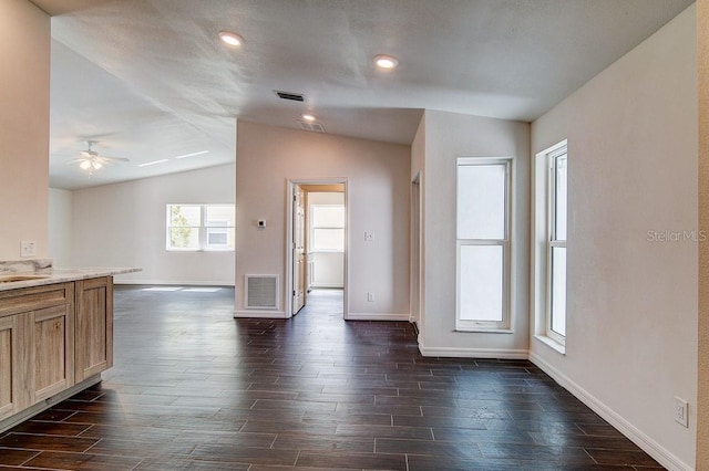 interior space featuring baseboards, visible vents, vaulted ceiling, and dark wood-style flooring