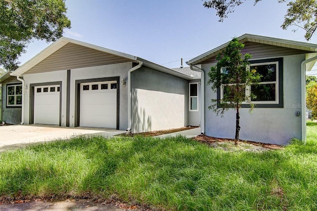 ranch-style home with concrete driveway, an attached garage, and stucco siding