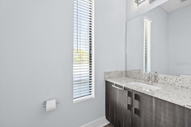 bathroom featuring visible vents, vanity, and baseboards