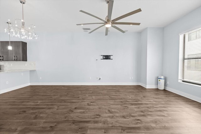 unfurnished living room with visible vents, baseboards, dark wood finished floors, and ceiling fan with notable chandelier