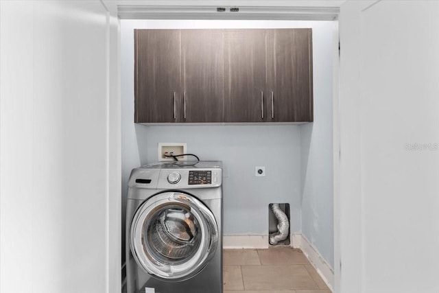 laundry room with light tile patterned floors, washer / clothes dryer, cabinet space, and baseboards