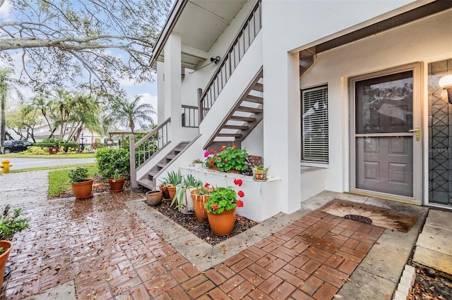 view of exterior entry with a patio and stucco siding