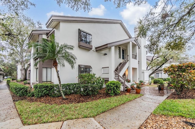 1822 Lake Cypress Dr Unit 1822, Safety Harbor, FL 34695 - view of side of home with stucco siding, stairway, and a chimney