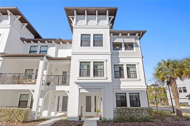 view of front of house featuring a balcony and stucco siding