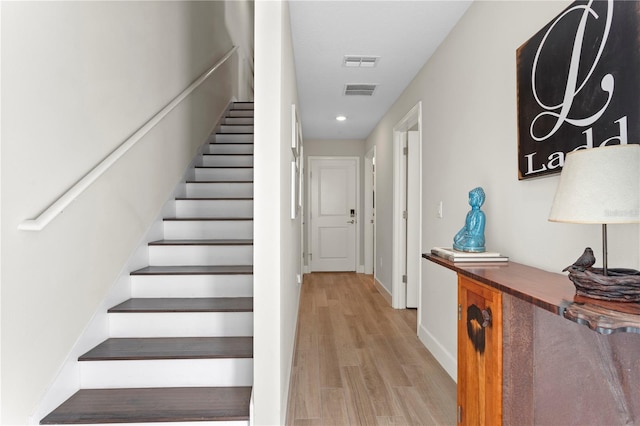 staircase featuring recessed lighting, wood finished floors, visible vents, and baseboards