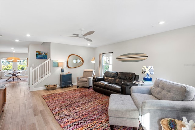 living area featuring light wood-type flooring, a healthy amount of sunlight, stairway, and recessed lighting