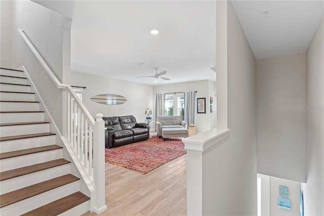 living room featuring light wood-type flooring, stairs, a ceiling fan, and recessed lighting