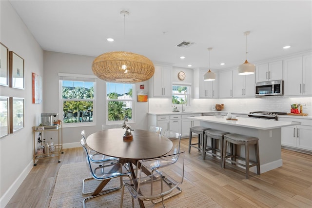 dining space with baseboards, recessed lighting, visible vents, and light wood-style floors