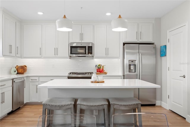 kitchen with stainless steel appliances, a breakfast bar area, and white cabinets