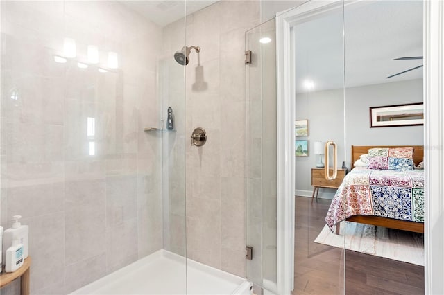 ensuite bathroom featuring ensuite bathroom, a stall shower, and wood finished floors