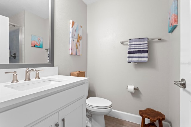 full bathroom featuring toilet, an enclosed shower, vanity, wood finished floors, and baseboards