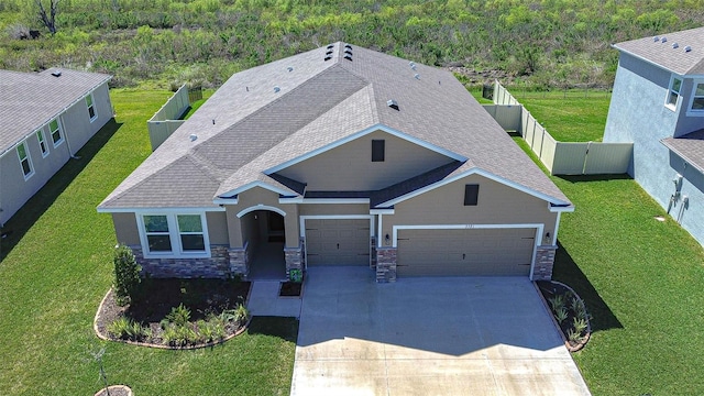 view of front facade with stone siding, fence, a front lawn, and concrete driveway