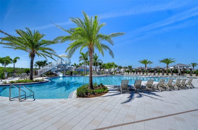 pool with a water slide and a patio