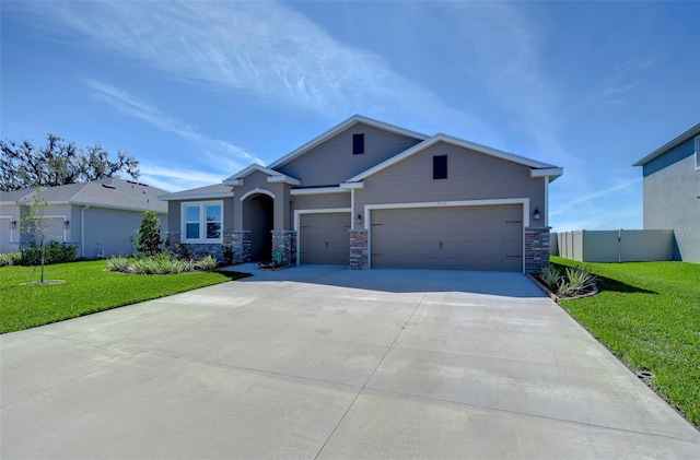 view of front of house with an attached garage, stone siding, concrete driveway, and a front yard