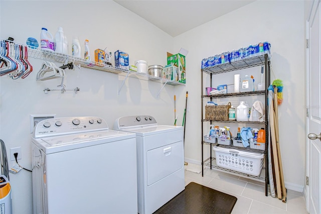 washroom featuring laundry area, light tile patterned floors, baseboards, and separate washer and dryer